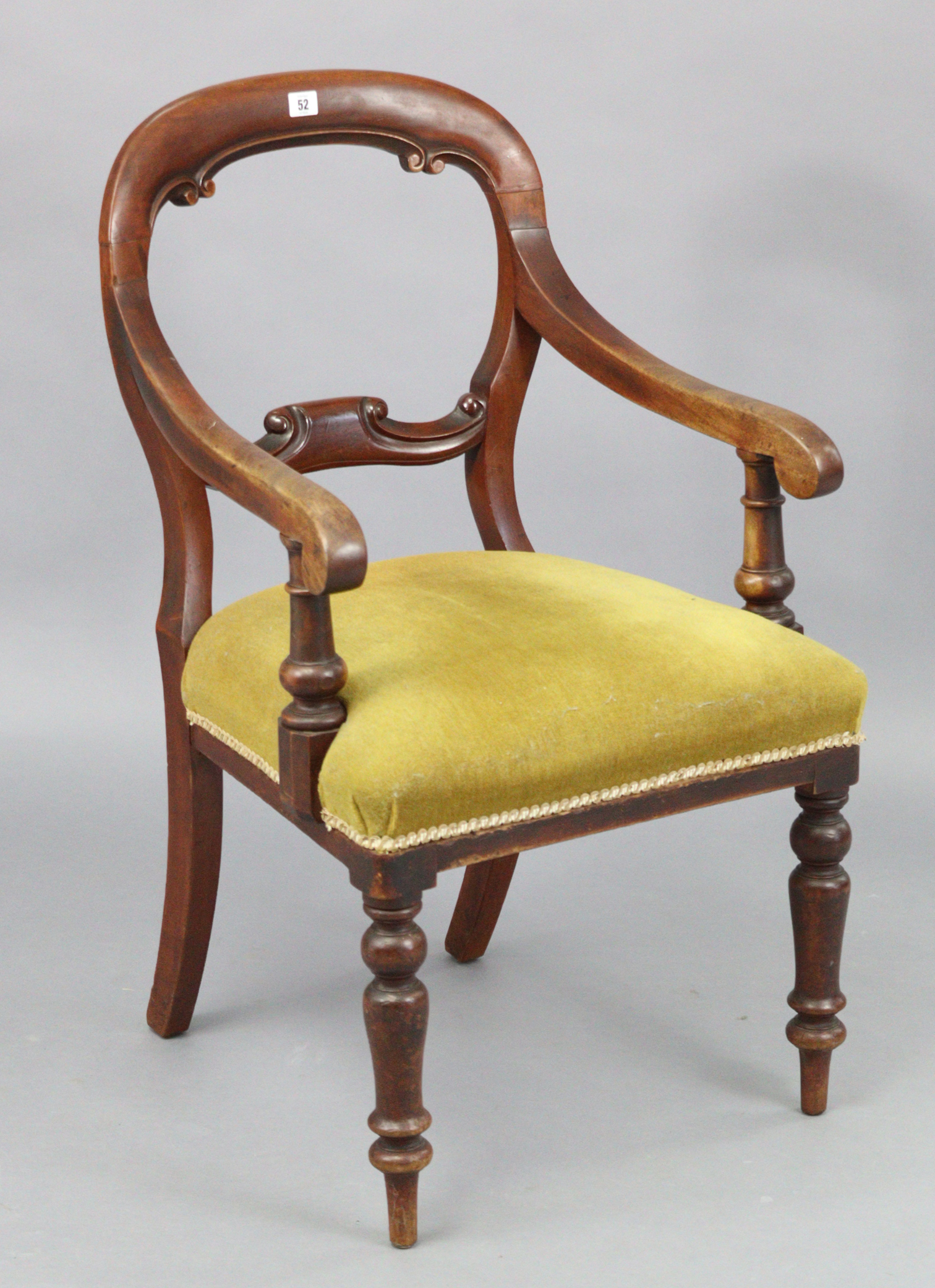 A Victorian mahogany balloon back carver chair, with padded seat & on turned tapered legs.