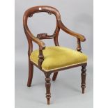 A Victorian mahogany balloon back carver chair, with padded seat & on turned tapered legs.