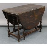 A 1930’s oak oval gate-leg dining table, on barley-twist legs & turned feet with plain stretchers,