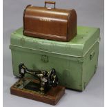 A Singer hand sewing machine in oak case; together with a pale green painted tin domed-top