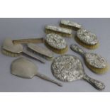 An Edwardian silver embossed-backed six-piece dressing table set; & a silver engine-turned backed
