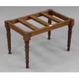 A late Victorian mahogany luggage rack on four ring-turned tapered legs, 24½” wide x 15” high.