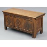 A reproduction oak coffer with hinged lift-lid, & with carved panel front, 42” wide x 20¾” high.