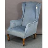 A Georgian-style wing-back armchair upholstered pale blue velour, & on short cabriole legs & pad