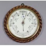 A late 19th century/early 20th century large aneroid wall barometer with white enamel dial, & in oak