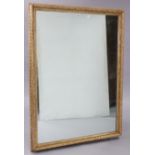 A large gilt frame rectangular wall mirror with raised scroll border, 37½” x 50”.