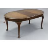 An Edwardian mahogany extending dining table with moulded edge & rounded ends to the rectangular