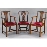 A pair of Hepplewhite style carved mahogany elbow chairs with pierced splat backs, curved open