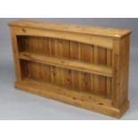 A pine dwarf standing open bookcase, with two adjustable shelves & on plinth base, 52” wide x 30½”