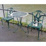 A green painted aluminium circular patio table with pierced circular top & on three shaped legs, 27”