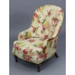 A late Victorian buttoned-back nursing chair upholstered floral material, & on short turned legs