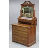 An Edwardian walnut dressing chest with rectangular swing mirror to the stage back, fitted three