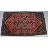 A Persian pattern rug of crimson & deep blue ground, & with repeating multi-coloured geometric
