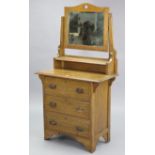 An Edwardian small oak dressing chest, with rectangular swing mirror to the stage back, & fitted