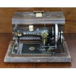 A Singer hand sewing machine in walnut dome-top case (decoration worn); & an Ancos ditto.