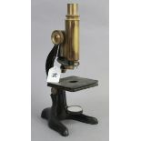 A mid-20th century black lacquered monocular microscope with brass fittings, 12½” high, lacking