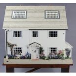 A PAINTED WOODED THREE-STOREY DOLLS HOUSE with opening front & hinged roof, 39½” wide x 33¼” high