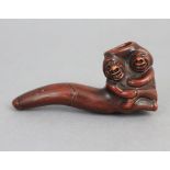 A Japanese pottery erotic smoking pipe, an embracing couple forming the bowl; 3¾” long.