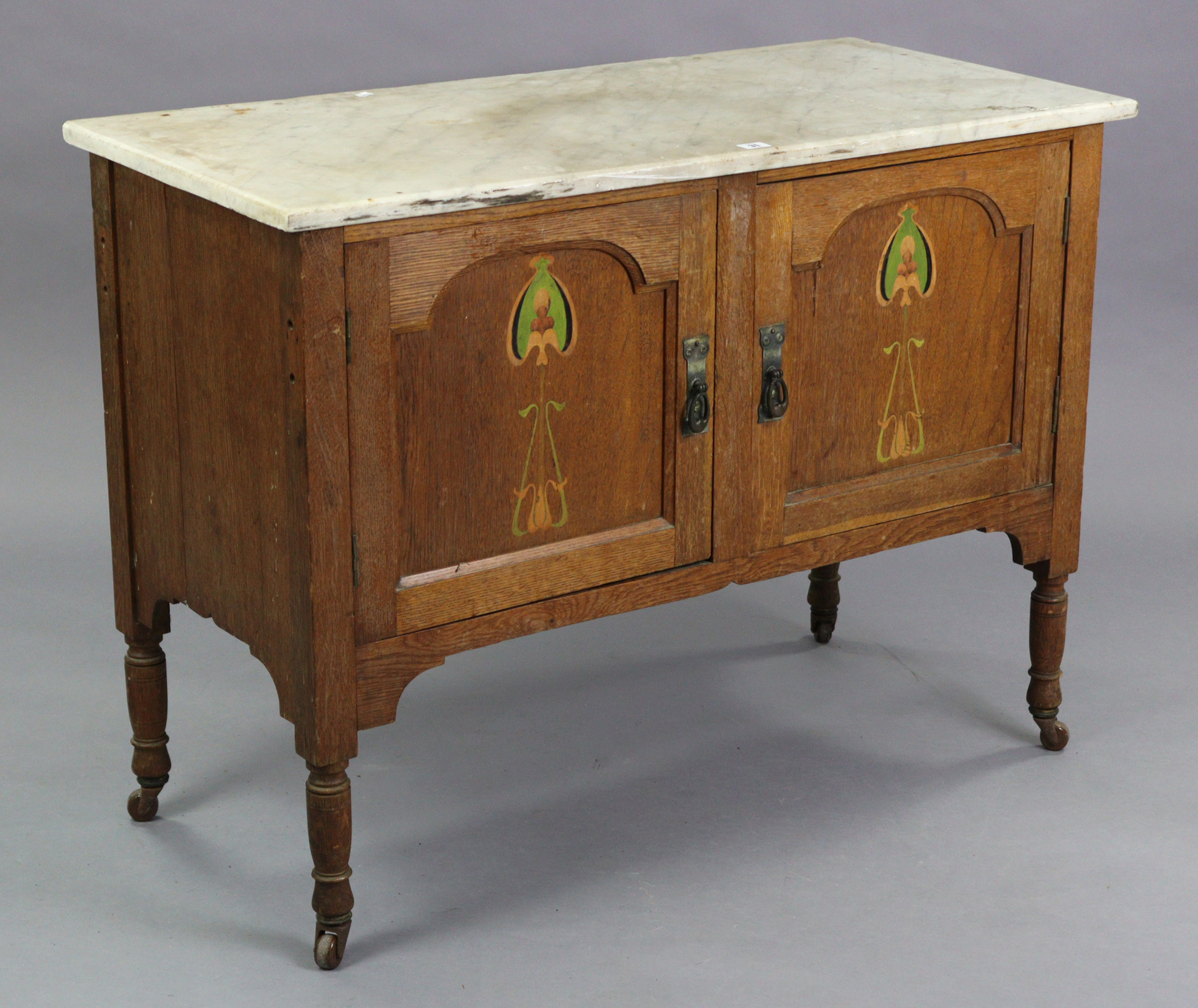 An Edwardian oak marble-top washstand enclosed by pair of panel doors with painted Arts & Crafts sty