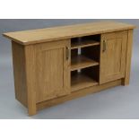 A light oak-finish low side cabinet with two adjustable shelves to centre & flanked by cupboard to