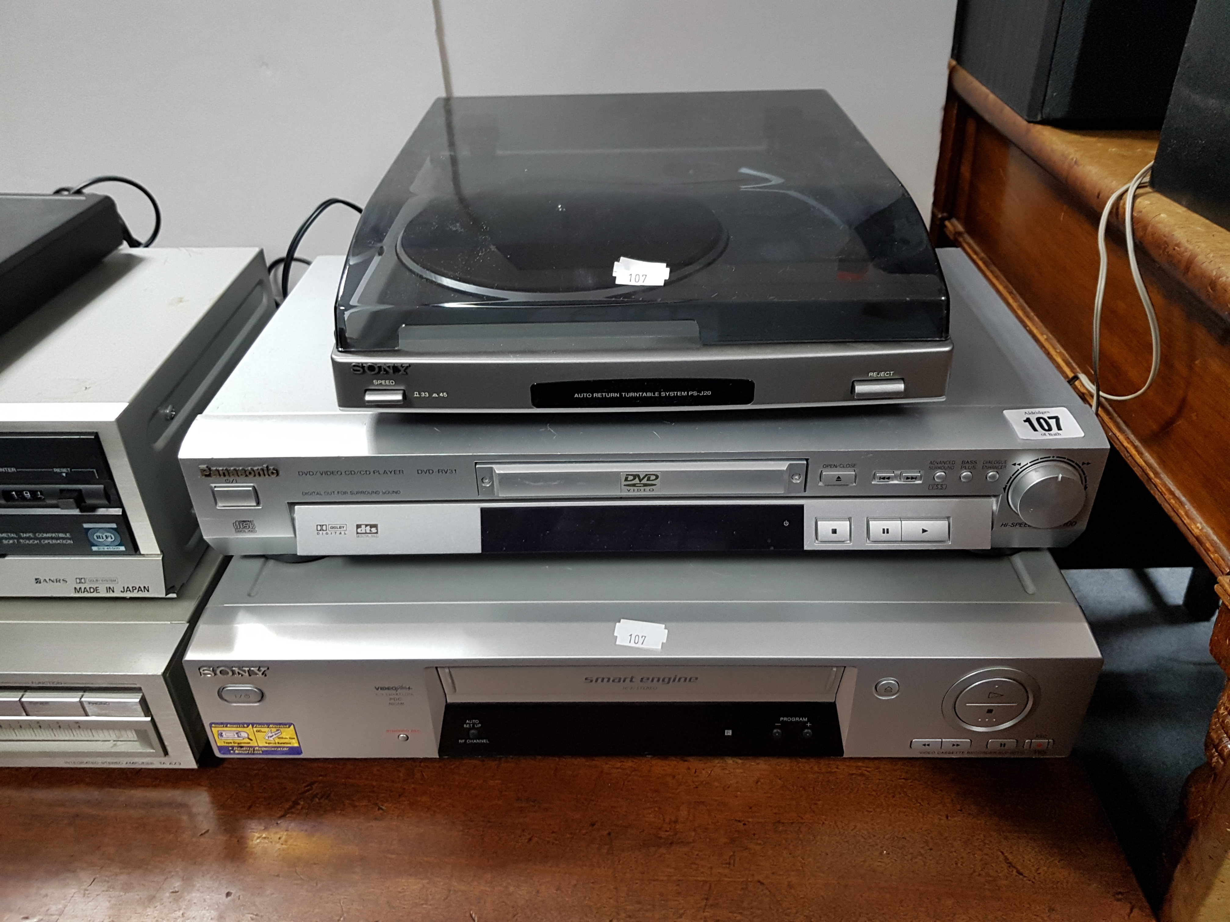 A Sony radio receiver; a Panasonic DVD player; a Sony turntable; a Sony video cassette recorder; & a