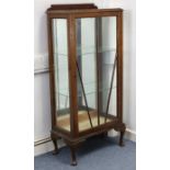 A mid-20th century oak china display cabinet fitted two plate-glass shelves enclosed by a glazed