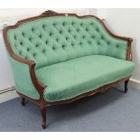 A VICTORIAN CARVED WALNUT FRAME SMALL SOFA with floral crest to the curved back, acanthus scroll