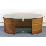 A contemporary walnut-finish oval low side table with tampered-glass top above two tempered-glass