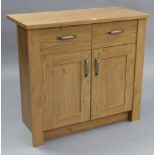 A light oak-finish small sideboard fitted frieze drawer above cupboard enclosed by pair of doors,