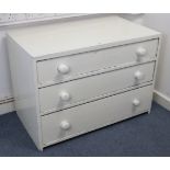 A white painted pine low chest, fitted three long graduated drawers with turned knob handles, 39”