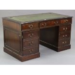 A reproduction mahogany pedestal desk inset gilt-tooled green leather, fitted two long drawers to