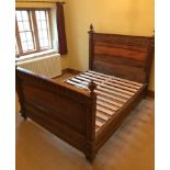 A continental-style walnut double bedstead the head & footboard each with moulded scroll frieze & on