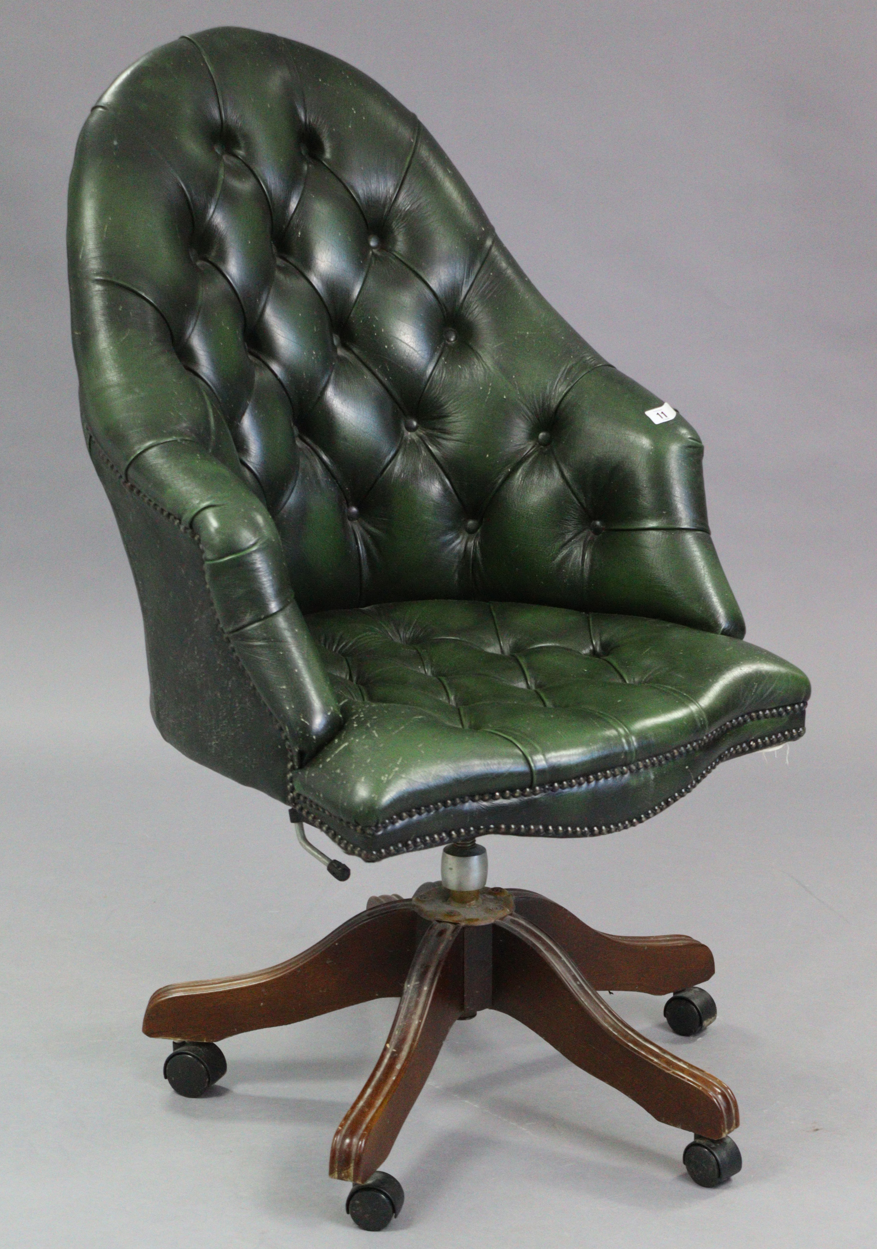 A buttoned green leather swivel desk chair.