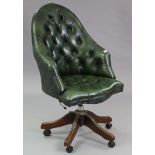 A buttoned green leather swivel desk chair.
