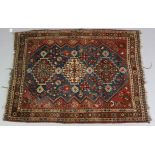 A Persian pattern rug of deep blue & crimson ground, & with repeating geometric design to centre