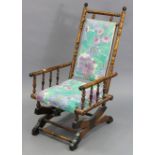An early 20th century carved beech-frame rocking chair with padded seat & back & on sprung base.