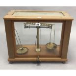 A Galenkamp brass laboratory balance in mahogany case, 18” wide; together with four wooden tennis