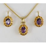 An 18ct. gold oval pendant set amethyst within a border of small citrines, on 18ct. chain necklet; &