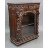 A 17th century style oak side cabinet with all-over carved foliate decoration, fitted frieze