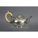 A George IV silver teapot of compressed round form, with ivory scroll handle & finial to the