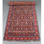 An antique Persian runner with repeating multicoloured geometric foliate design on a dark blue