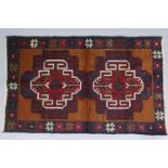 A Baluchi rug of dark blue ground, with central lozenge-shaped designs in ivory, red, & green, on an