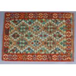 A Choli kelim rug of orange ground with repeating lozenge motif within wide border, 32” x 48”.