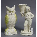 A Belleek porcelain candle holder in the form of a standing boy holding a basket on his shoulder,