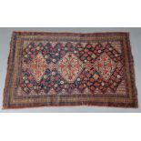 An antique Persian rug of deep blue ground with central row of three lozenges on a background of