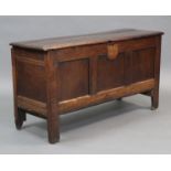 An 18th century oak coffer with hinged lift lid, three fielded panels to the front and on short