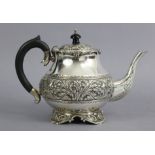 A continental white metal teapot of compressed round form, with hinged lid & repoussé bands of