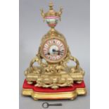 A 19th century French mantel clock in gilt speltre case with 3¼” diam. pink ground Sevres-style