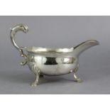 A George II silver sauce boat with cut-card rim, open leaf-scroll handle, & on three shell & hoof