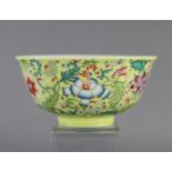 A Chinese porcelain yellow-ground bowl, decorated in famille-rose enamels with scrolling flowers,